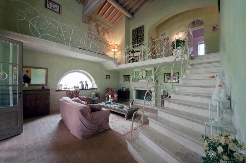 卡索莱德尔萨La casa di Arianna的客厅设有楼梯、沙发和桌子