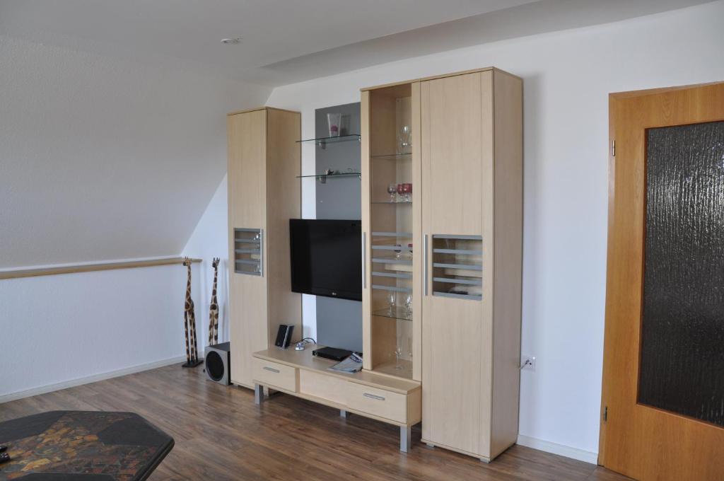 FuldatalFewo-Fuldatal的一间带电视和木制橱柜的客厅