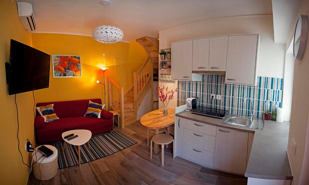科佩尔Apartment Koper的一间带红色沙发的客厅和一间厨房