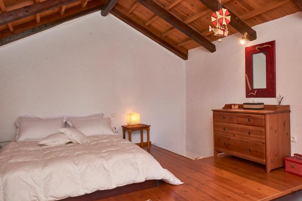 桑加拉达Red Villa's Guesthouse的卧室配有白色的床和木制梳妆台。