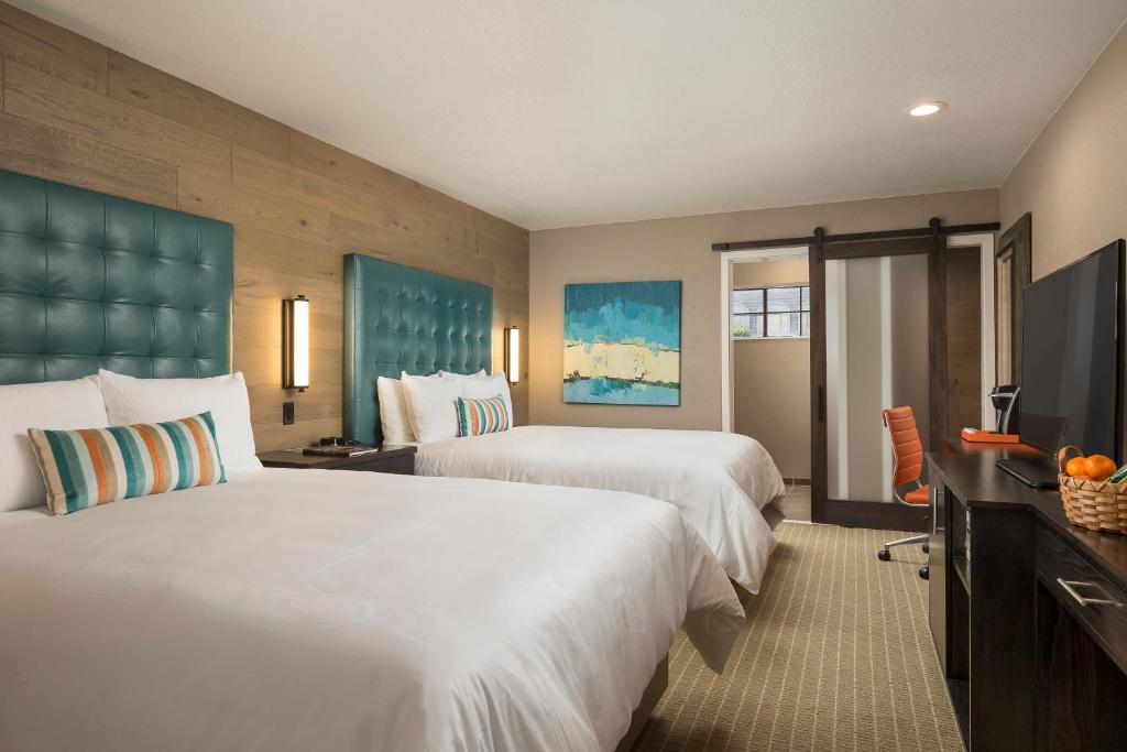 蒙特雷水獭宾馆的酒店客房设有两张床和一台平面电视。
