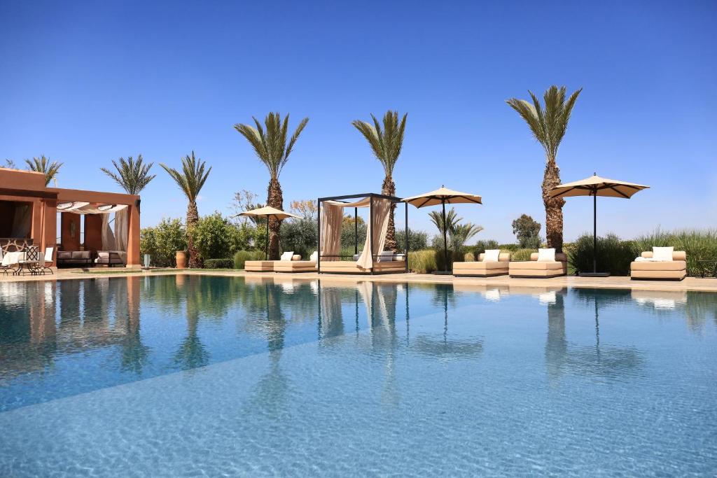 马拉喀什达尔索菲尔旅馆 - 仅限成人的一个带遮阳伞和棕榈树的大型游泳池