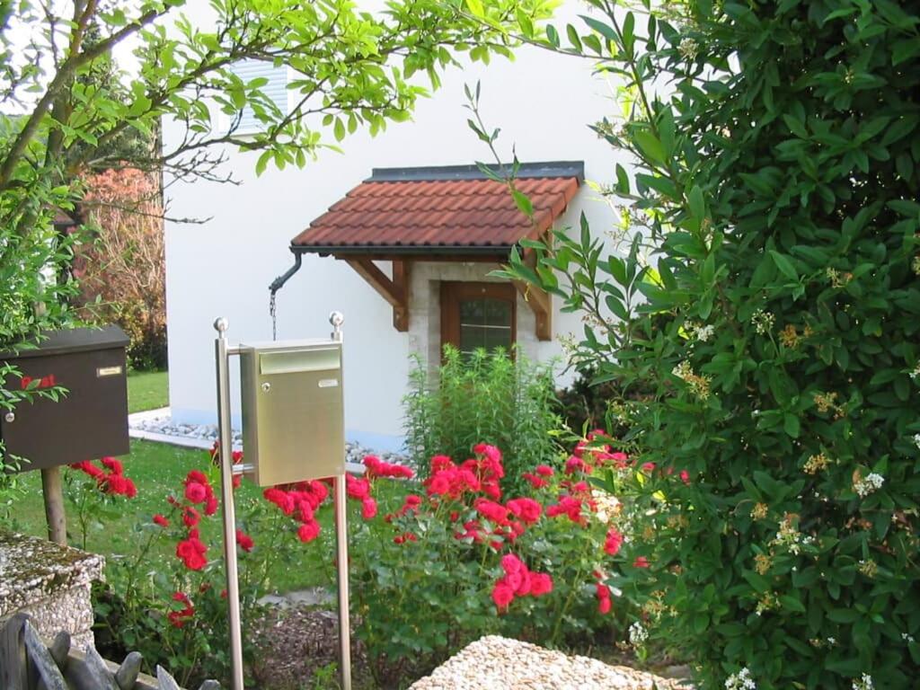 Illschwang格鲁恩公寓的花园中一座种有红色花的小房子