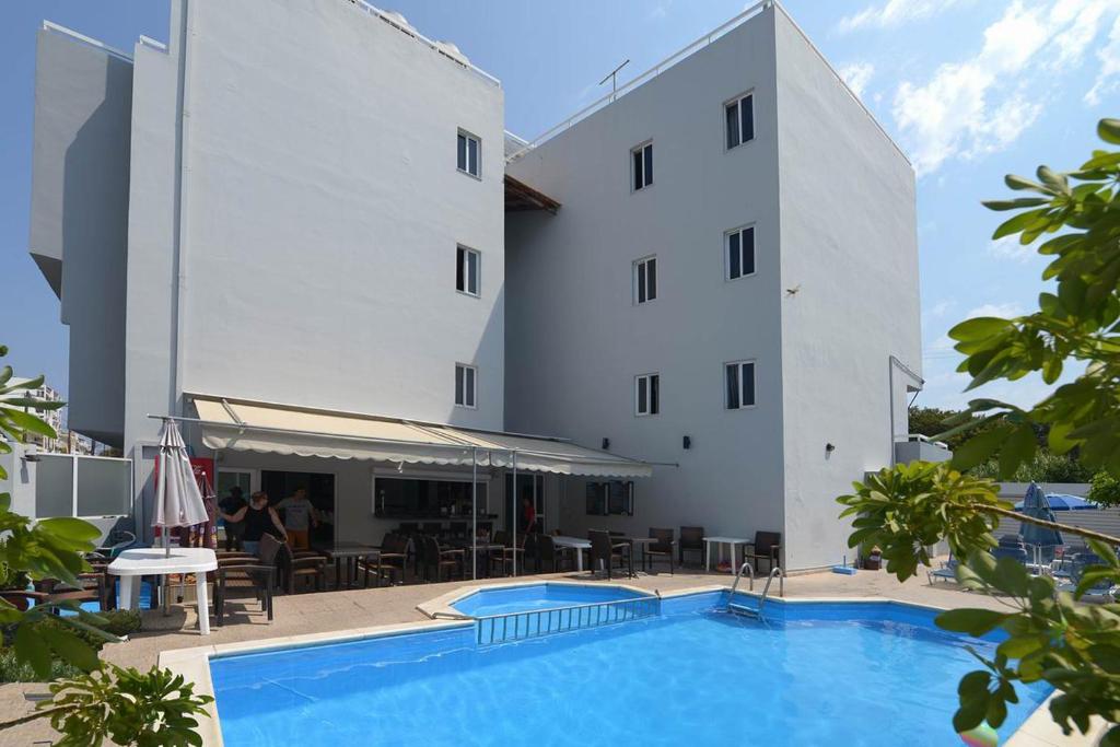 伊利索斯Ialysos City Hotel的大楼前设有游泳池的酒店