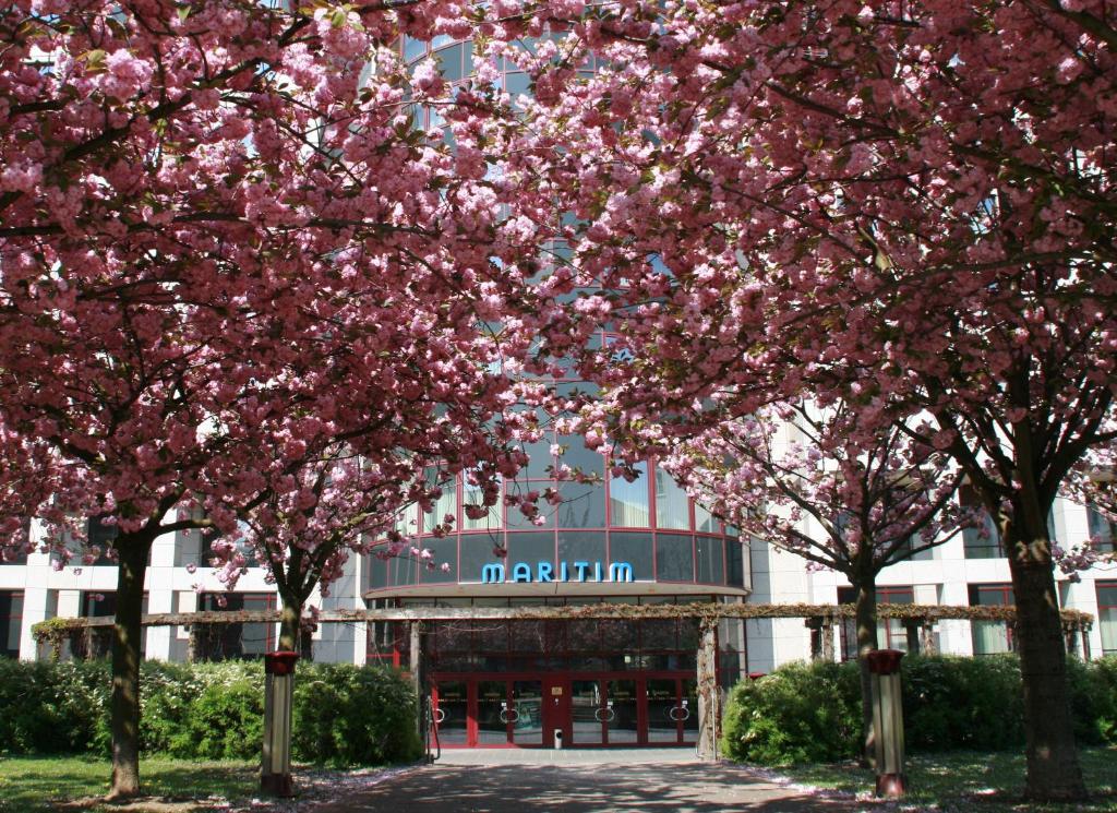 马格德堡玛丽蒂姆马格德堡酒店的一群在建筑物前有粉红色花的树木