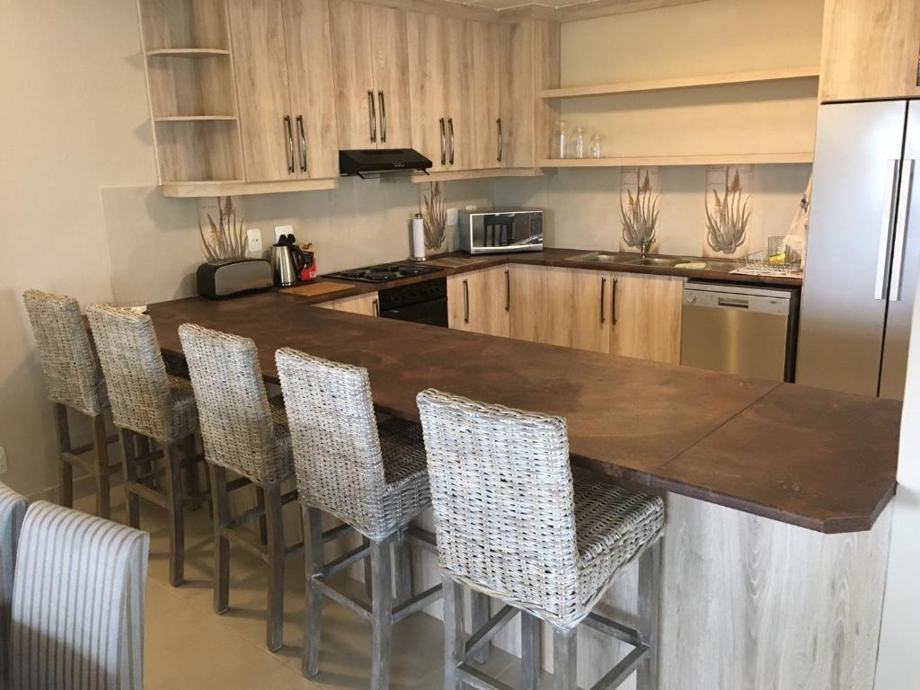 兰格班Sunset Heights的厨房配有带椅子的木台面和冰箱