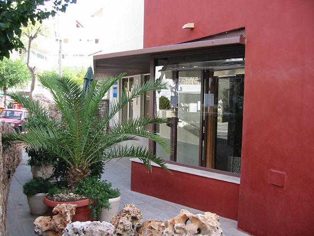 帕格拉苏提玛蕾斯丹西娅酒店的一座红色的建筑,前面有植物