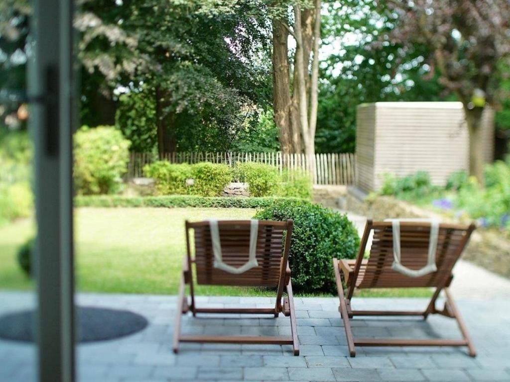 列日Gîte Au26 côté jardin-côté cour的花园庭院的两把椅子