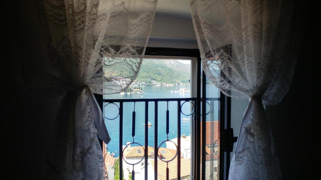 帕里斯特BellaVistaZmukic Guesthouse的透过窗帘的窗户可欣赏到水景