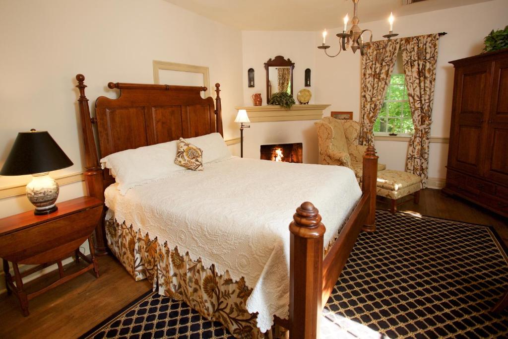 温斯顿·塞勒姆The Zevely Inn的一间卧室设有一张大床和一个壁炉