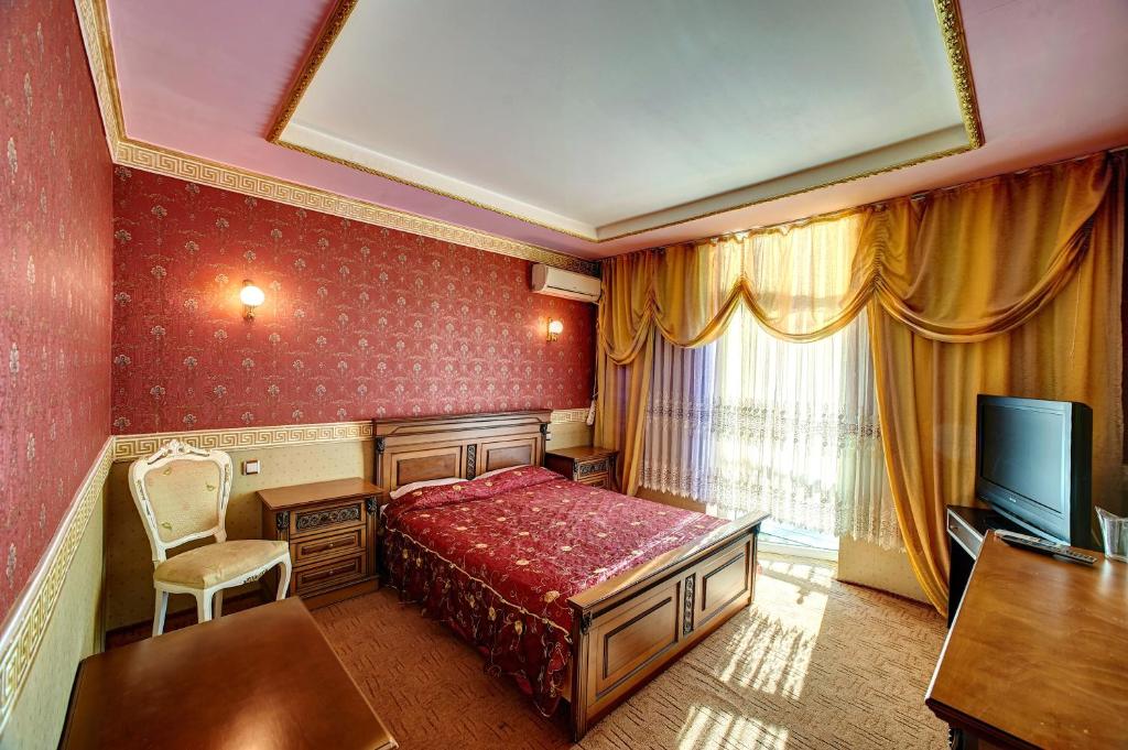 鲁塞怡日沃拉酒店的酒店客房配有一张床、一张书桌和一台电视。