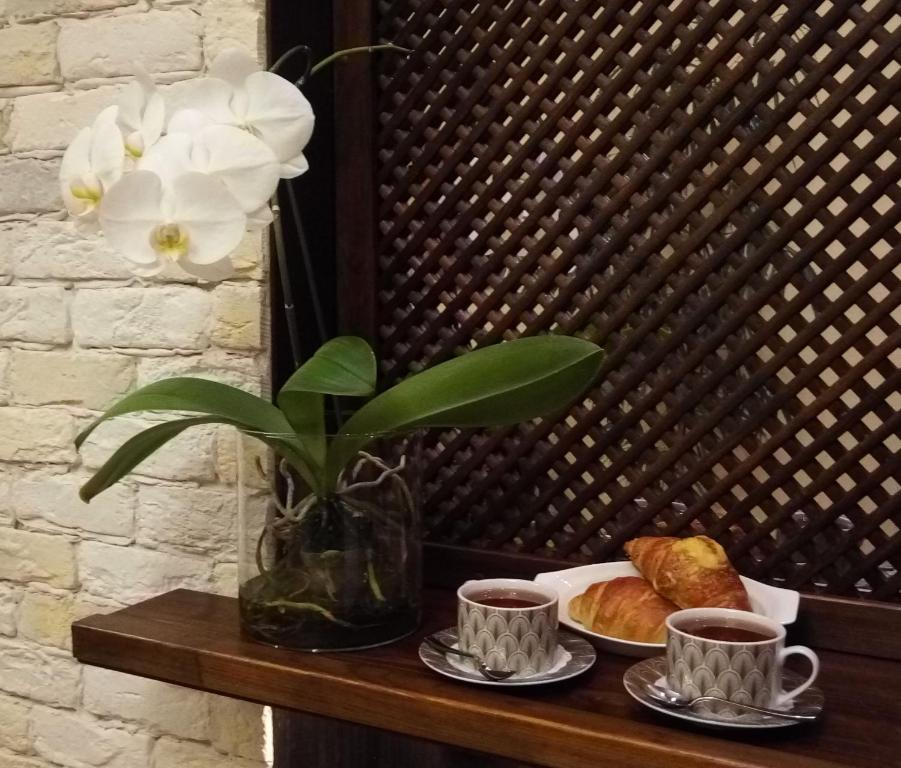 圣彼得堡My Favourite Garden的一张桌子,上面放着两杯咖啡和花瓶