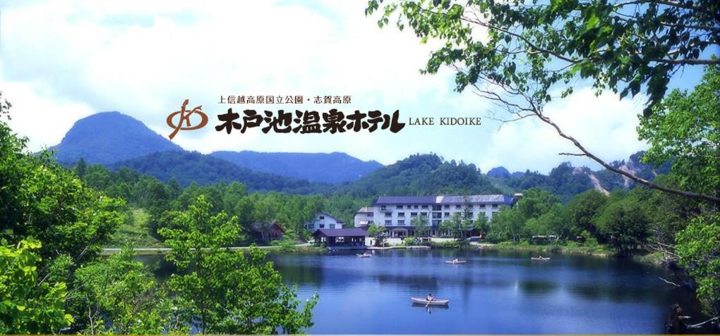 山之内町奇多伊科温泉酒店的享有以山脉为背景的湖泊美景