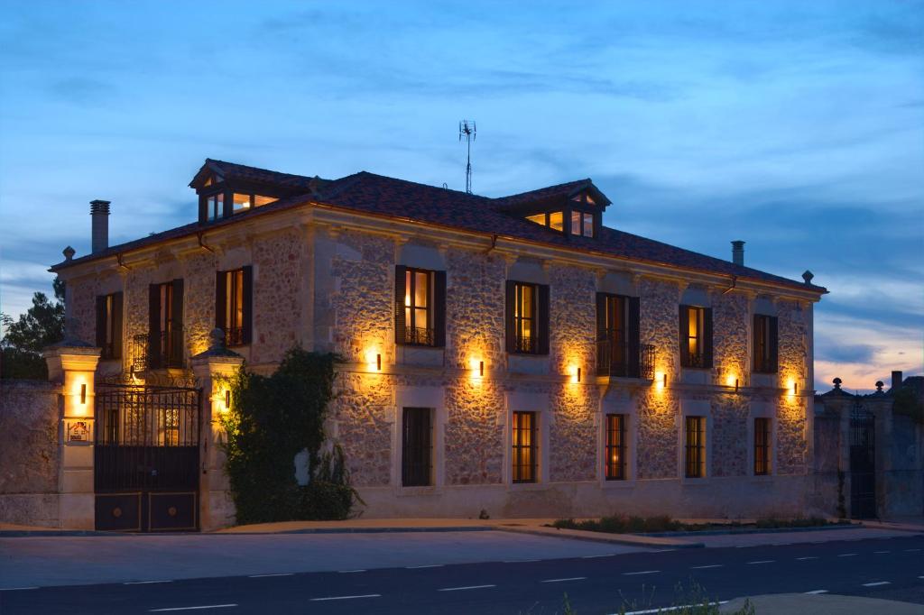 Aldeanueva De La Serrezuela 塞雷苏埃拉大人酒店的一座带灯光的大型石头建筑