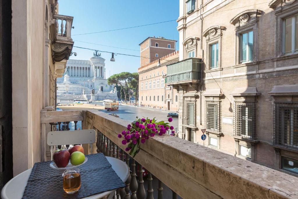 罗马Amazing Piazza Venezia Suites的阳台上的桌子上摆放着苹果和鲜花