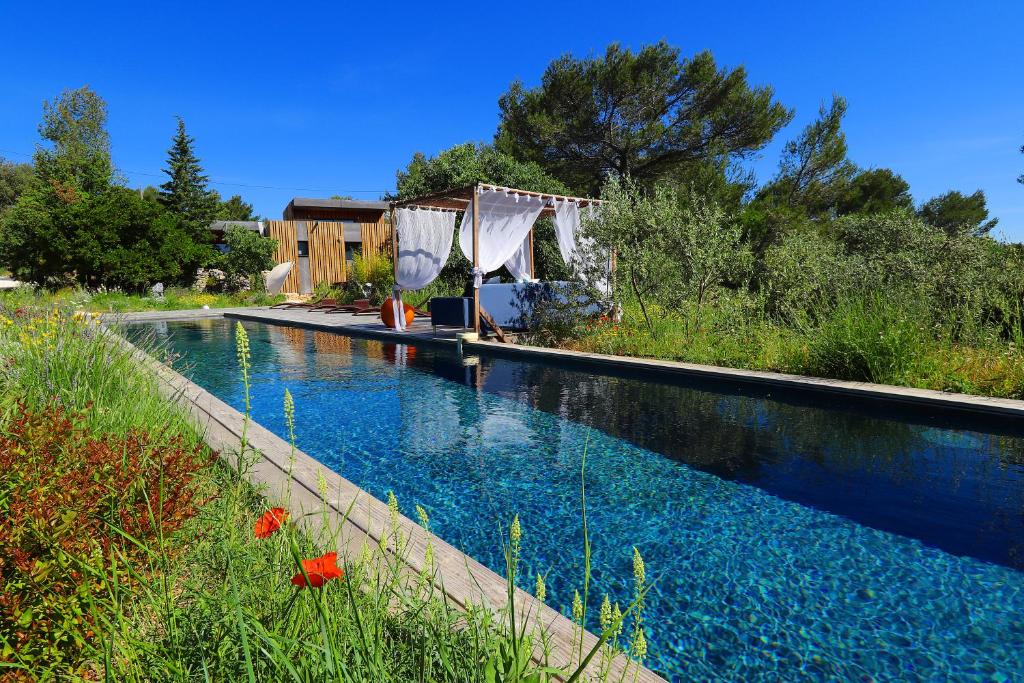 尼姆Bien Loin d'Ici Spa B&B的庭院里的一个蓝色海水游泳池