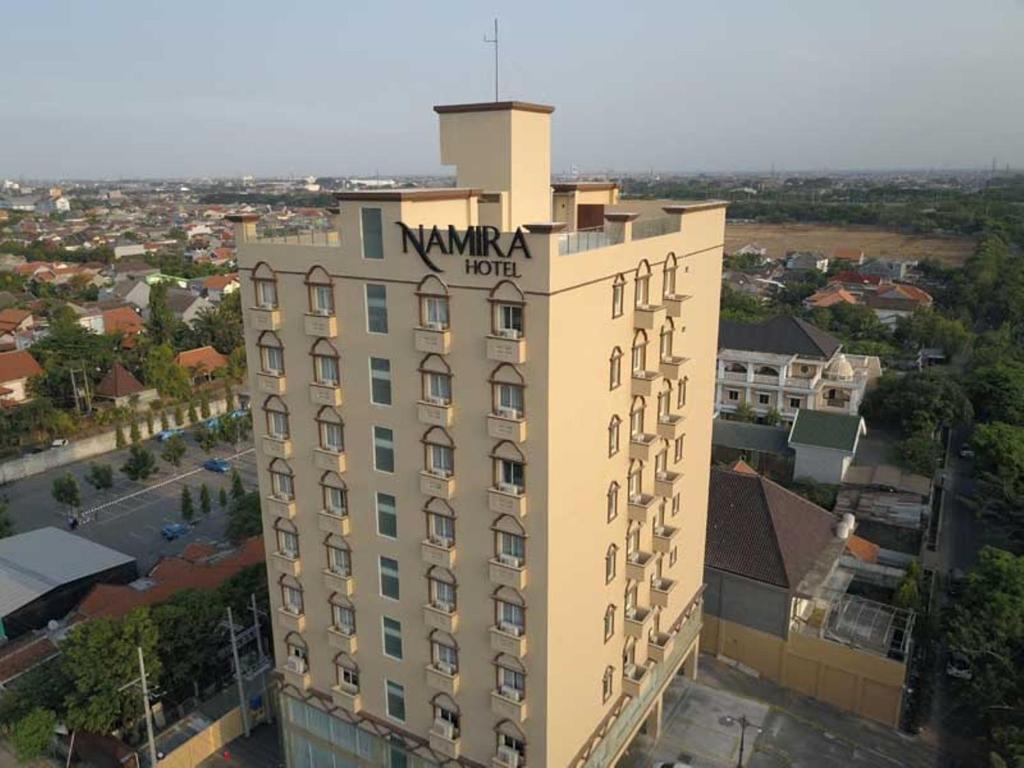 泗水Namira Syariah Hotel Surabaya的上面有酒店标志的建筑