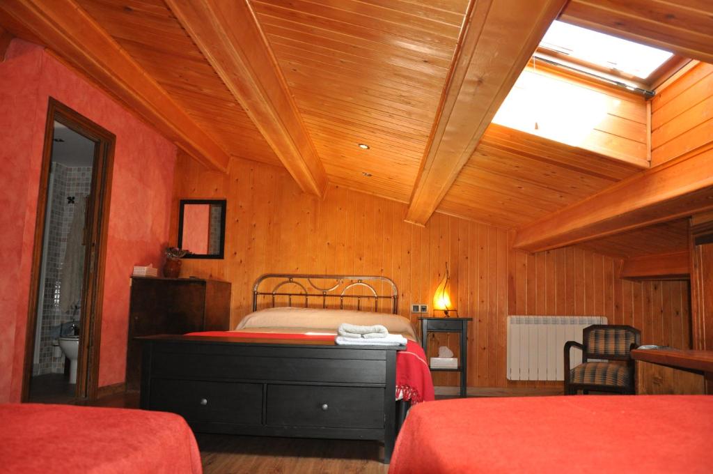El FragoLa Posada del Arba的一间卧室设有两张床和天窗