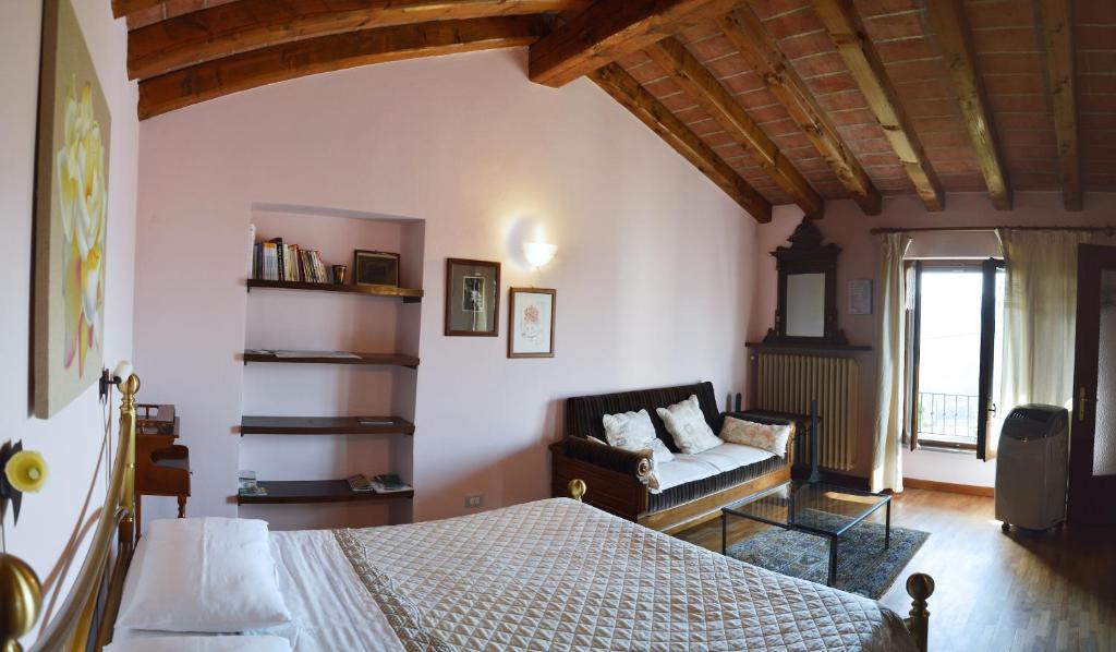 阿尔巴阿尔塔维拉提格里住宿加早餐旅馆的一间卧室配有一张床和一个沙发