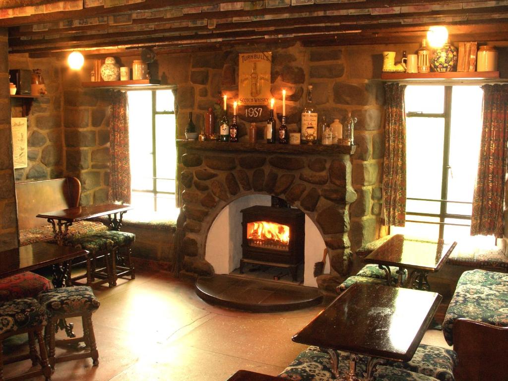克勒姆福特科尔菲尔酒店的餐厅内带石头壁炉的房间