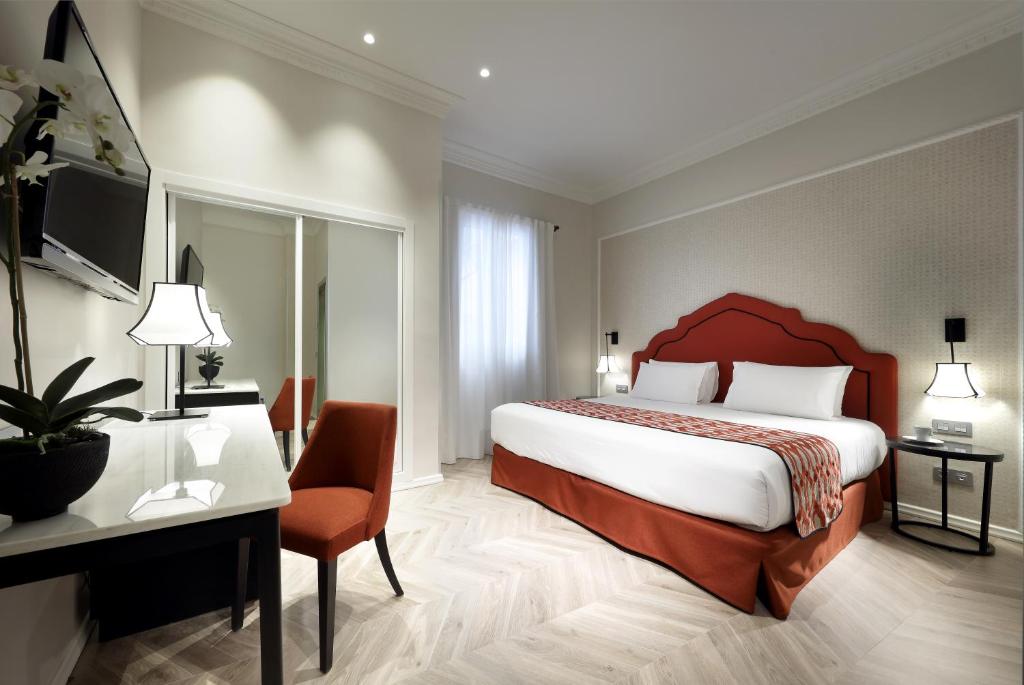塞维利亚瑞加纳欧洲之星酒店的酒店客房设有一张大床和一张书桌。