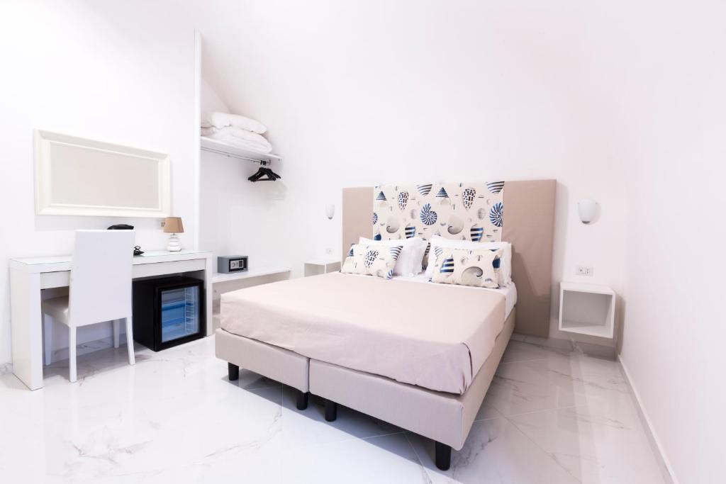 索伦托Holiday Sorrento Center的一间白色卧室,配有一张床和一个壁炉