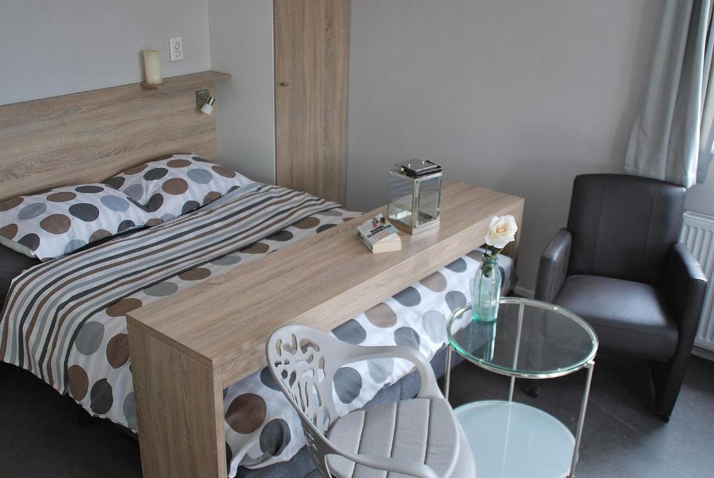 米德尔堡Hotel Chalets Middelburg的卧室配有1张床、1张桌子和1把椅子