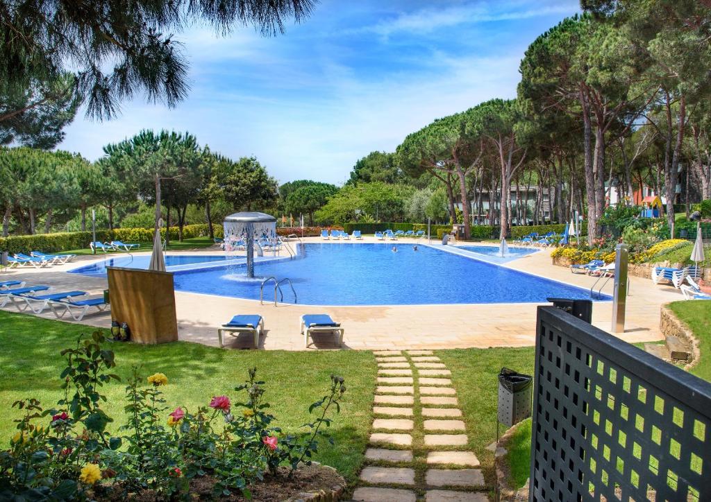 普拉加德阿罗帕洛尔城公寓式酒店的树木繁茂的公园里的一个大型游泳池