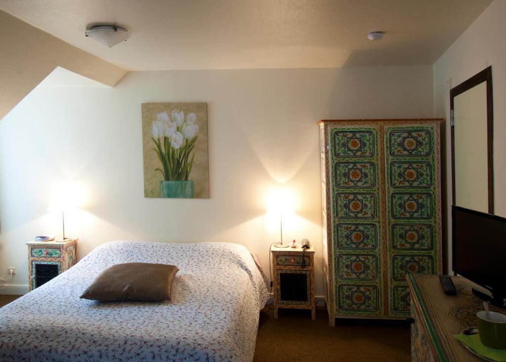 鲁汶德帕斯托里酒店的一间卧室配有一张床、两盏灯和一扇门