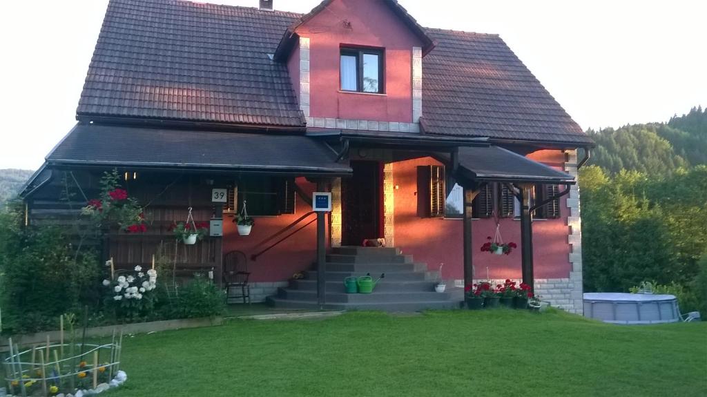 MoraviceApartman Anika的前面有一座绿色庭院的红色房子