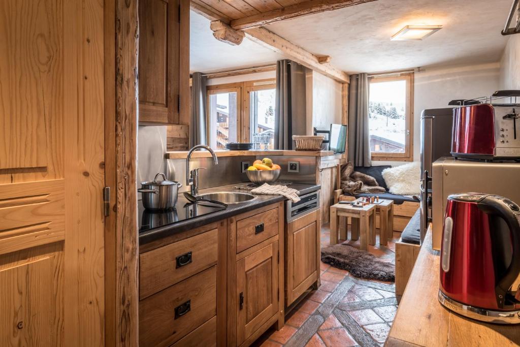 拉普拉尼马孔Agate的厨房配有木制橱柜、水槽和冰箱。