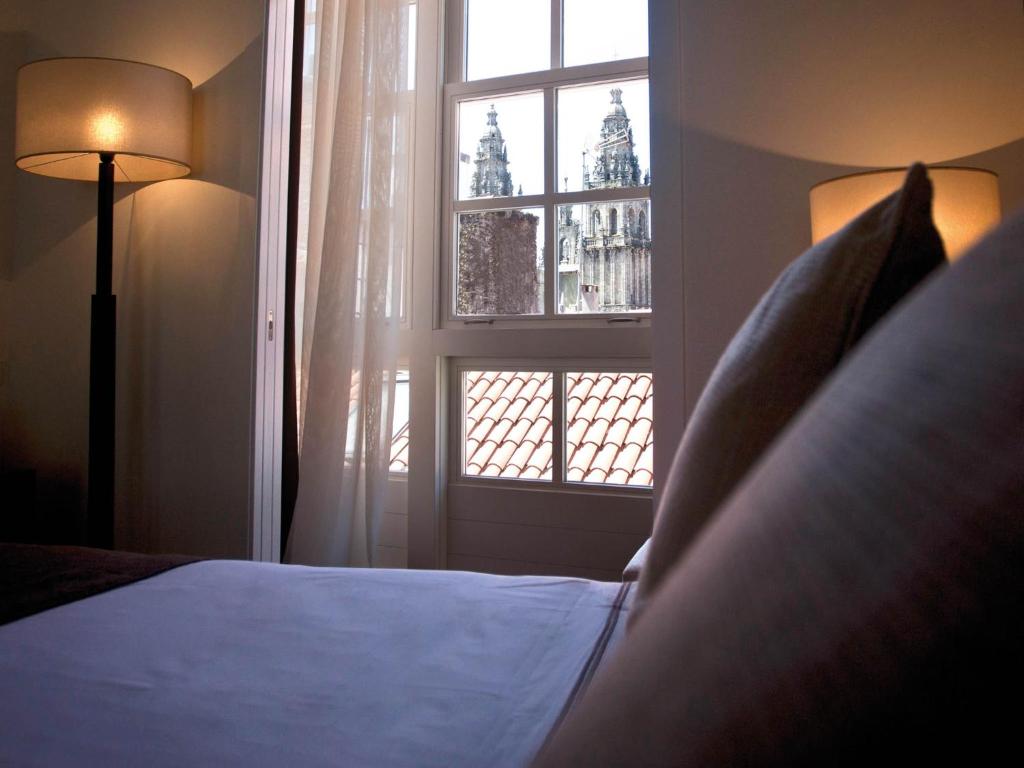 圣地亚哥－德孔波斯特拉Carris Casa de la Troya的一间卧室设有一张床和一个窗口
