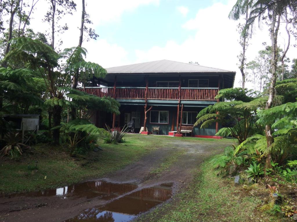 沃尔卡诺Aloha Crater Lodge的森林中带车道的房子