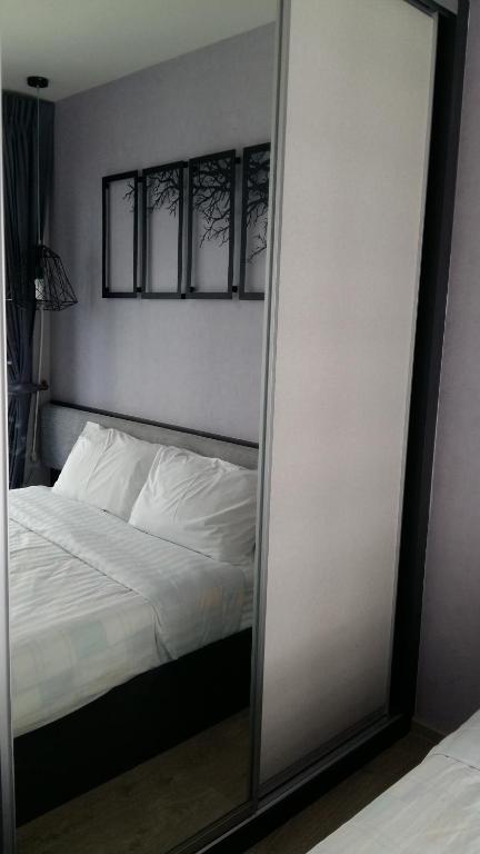芭堤雅市中心NKL管理的芭堤雅中央The BASE公寓的卧室前的镜子,卧室配有一张床