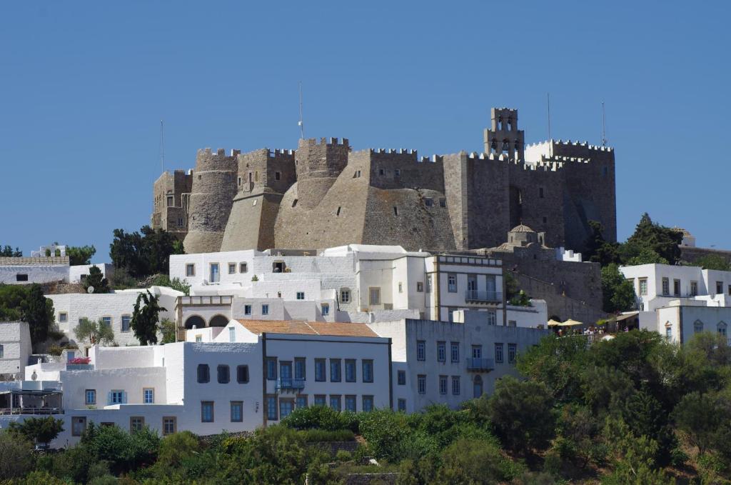 斯科拉埃菲酒店的一组白色的建筑,后面有城堡