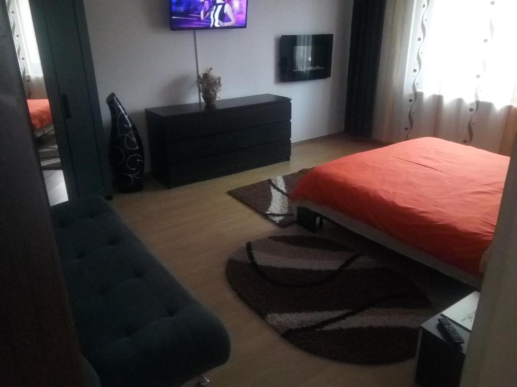 图尔达Casa Aurora的一间卧室配有一张床、一把椅子和电视