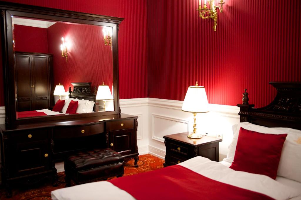 MándokForgách Kastély的红色卧室配有床和镜子