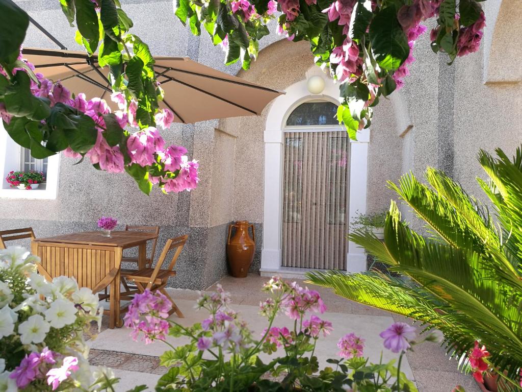 马丁纳弗兰卡La Grande Bellezza Trulli的庭院配有桌椅和鲜花