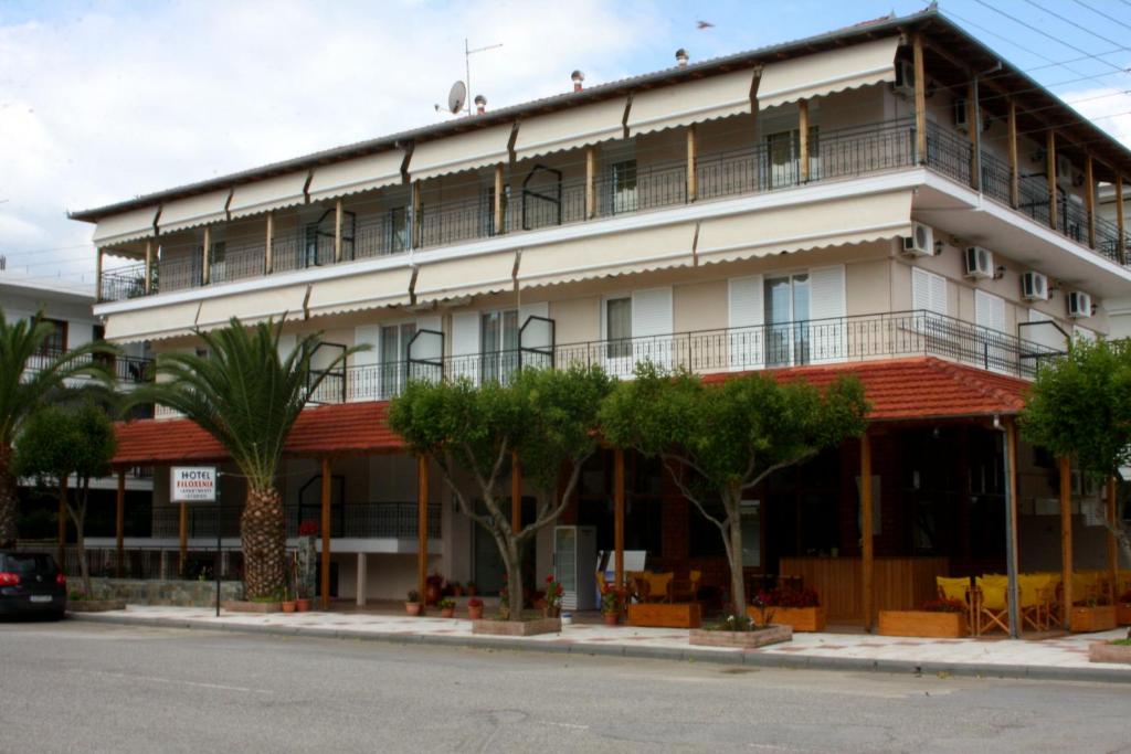 尼欧波洛伊Hotel Filoxenia的前面有树木的白色大建筑