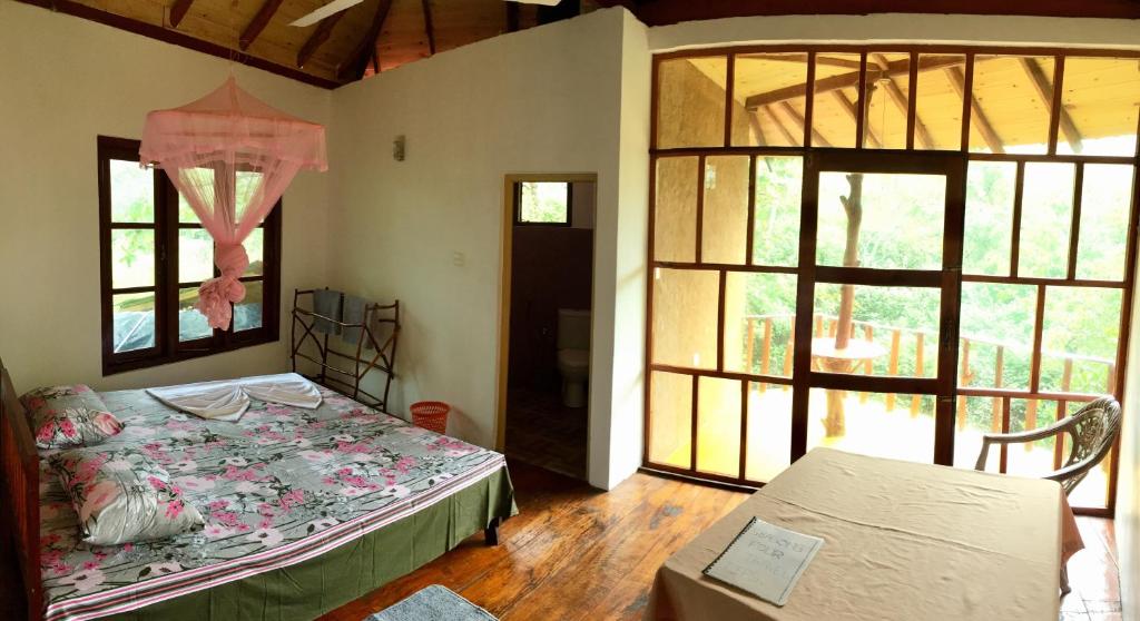 马特勒Seasons Four Mini Jungle Cabana的一间设有床铺的卧室,位于带窗户的房间内