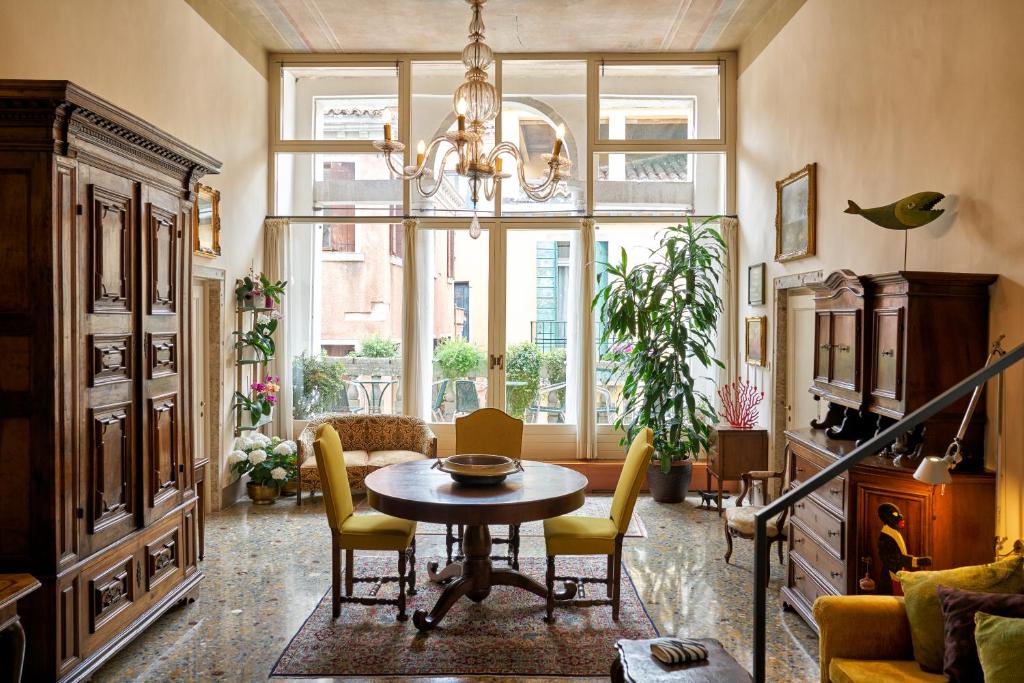 威尼斯坎皮耶洛禅意住宿加早餐旅馆的客厅配有桌椅和大窗户