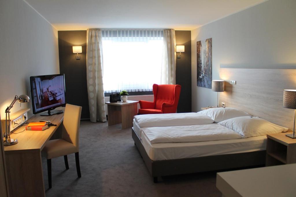 黑明根威斯特菲尔德酒店的配有一张床和一张书桌的酒店客房