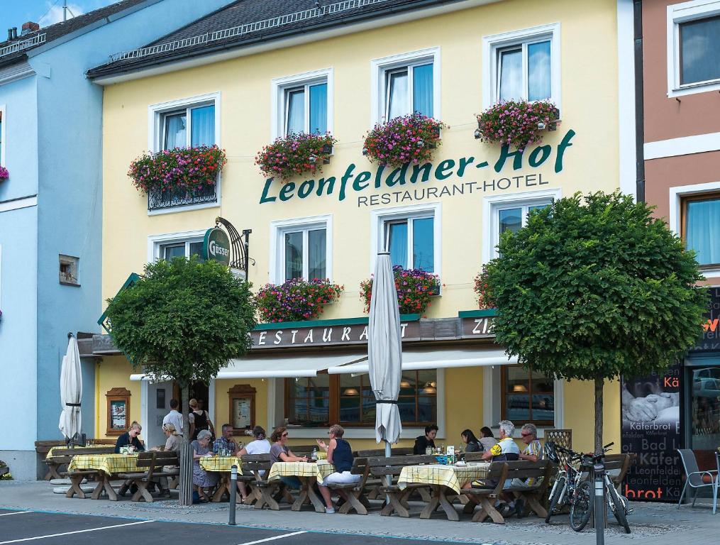 巴特莱昂费尔登Leonfeldner-Hof的坐在餐厅前桌旁的人