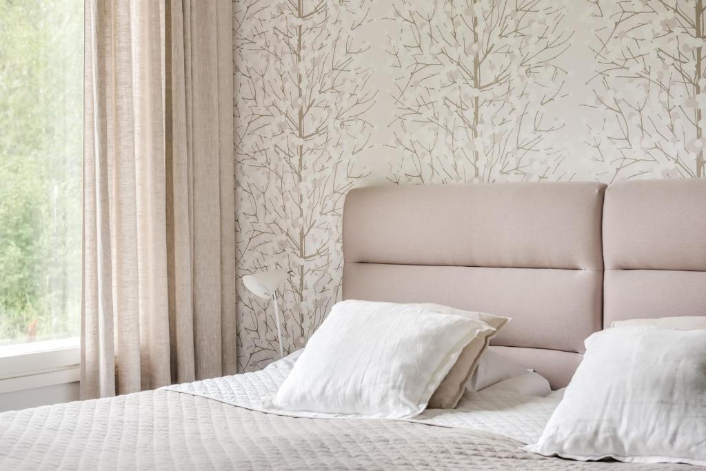 肯佩莱Apartment Kievarinhovi的卧室配有带白色枕头的床和窗户。