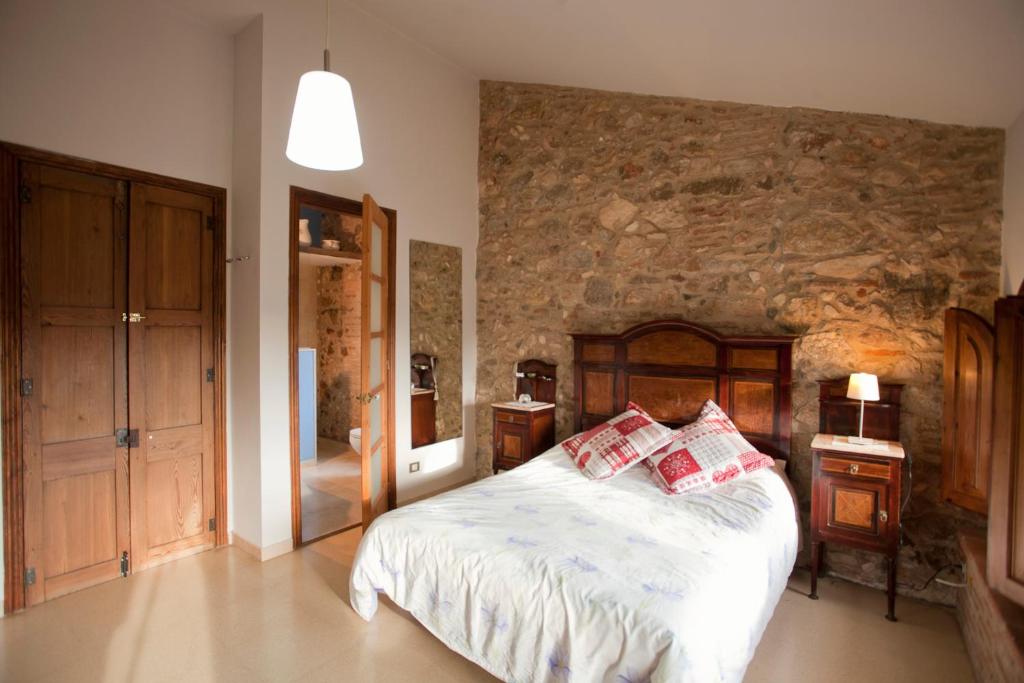 雷乌斯Mas del Molí的一间卧室设有一张床和石墙