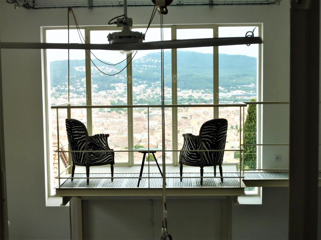 耶尔Grand Loft EM33的两把椅子坐在窗户前的阳台
