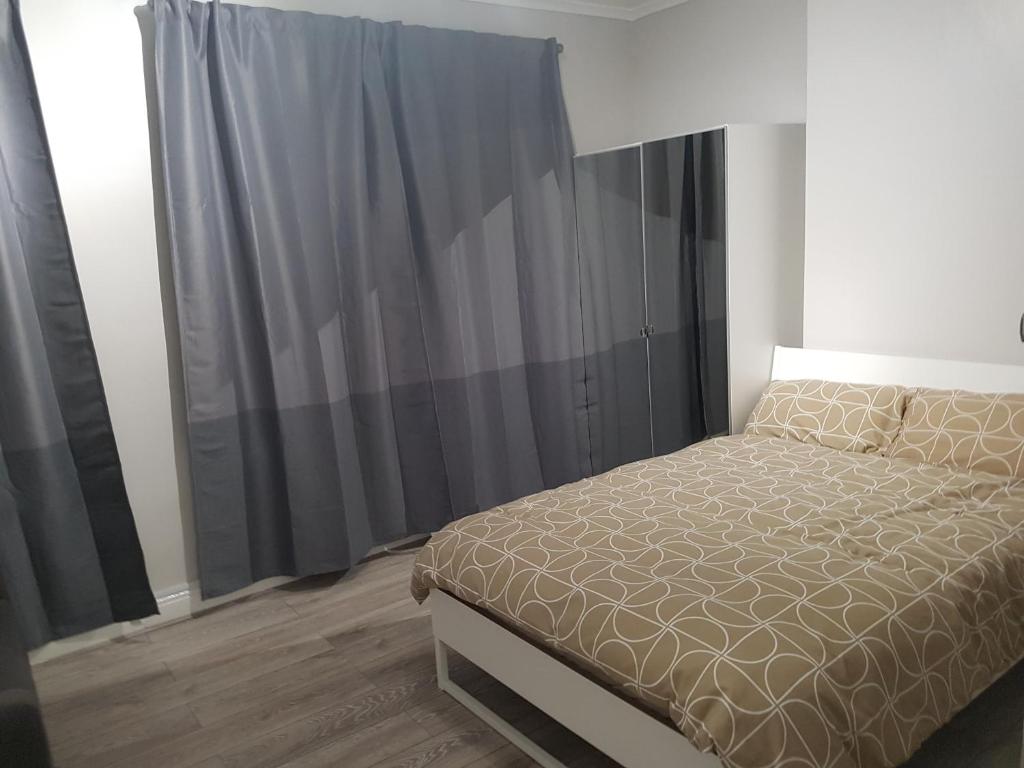 卡迪夫Court Road House的一间卧室配有床和黑色窗帘