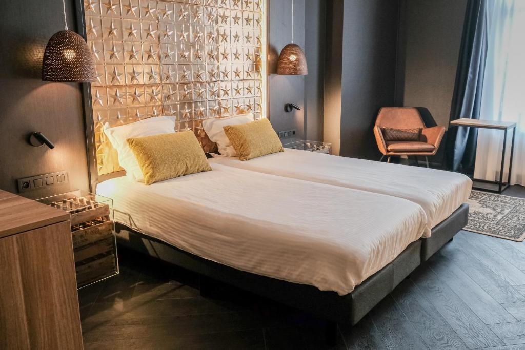 梅赫伦海特安加酿酒厂酒店的一间卧室配有一张大床和一把椅子