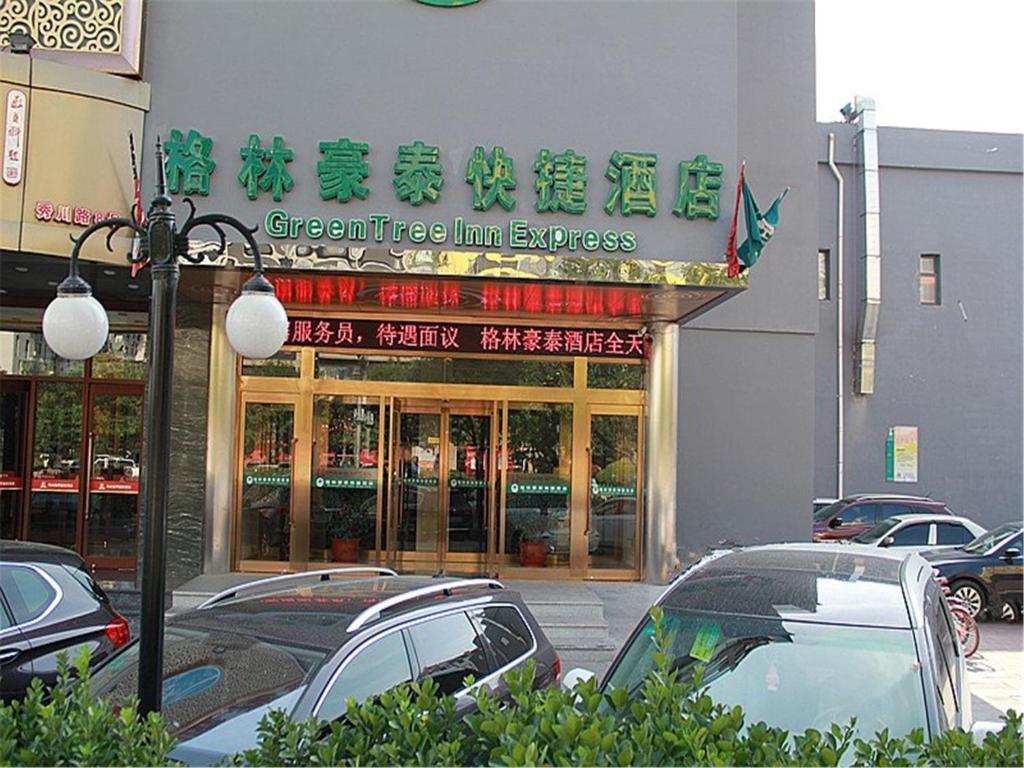 天津格林豪泰天津西青秀川路阳光100的一间商店,里面的汽车停在店前