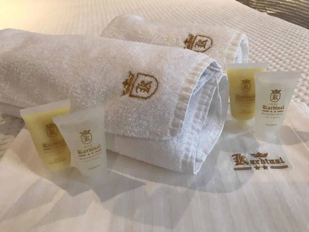布拉戈耶夫格勒卡迪纳尔酒店的一张带毛巾和三杯毛巾的床